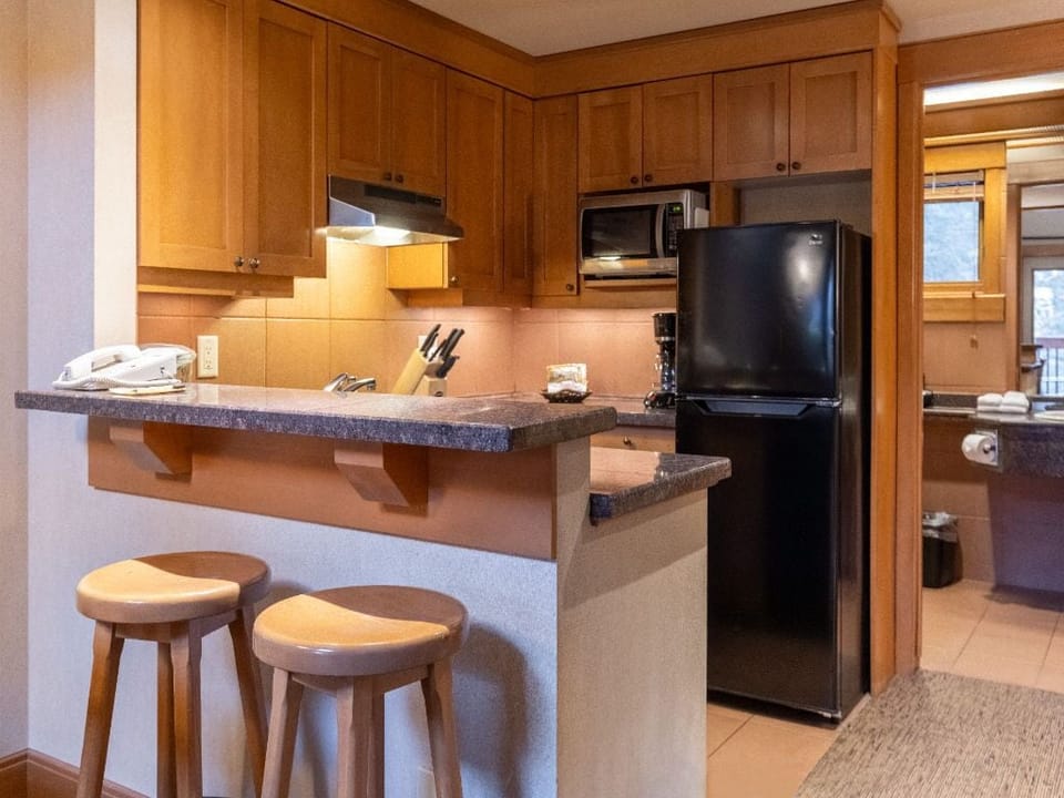 Enjoy the convenience of a fully equipped kitchen with a cozy breakfast bar, perfect for casual meals and gatherings.