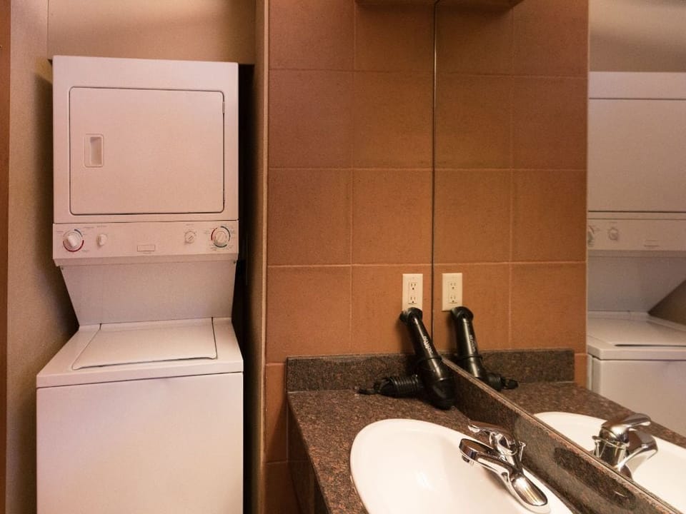 A thoughtfully designed bathroom with in-unit laundry ensures added comfort and convenience during your stay.