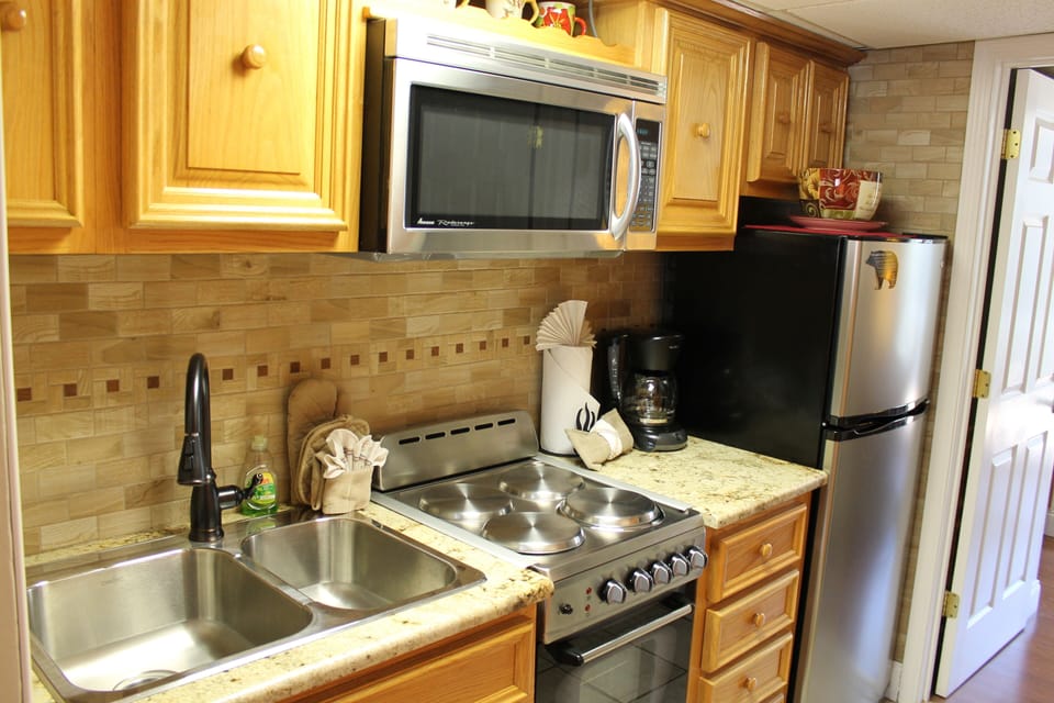 Newly renovated kitchen with granite cabinet tops and ceramic backsplash.
