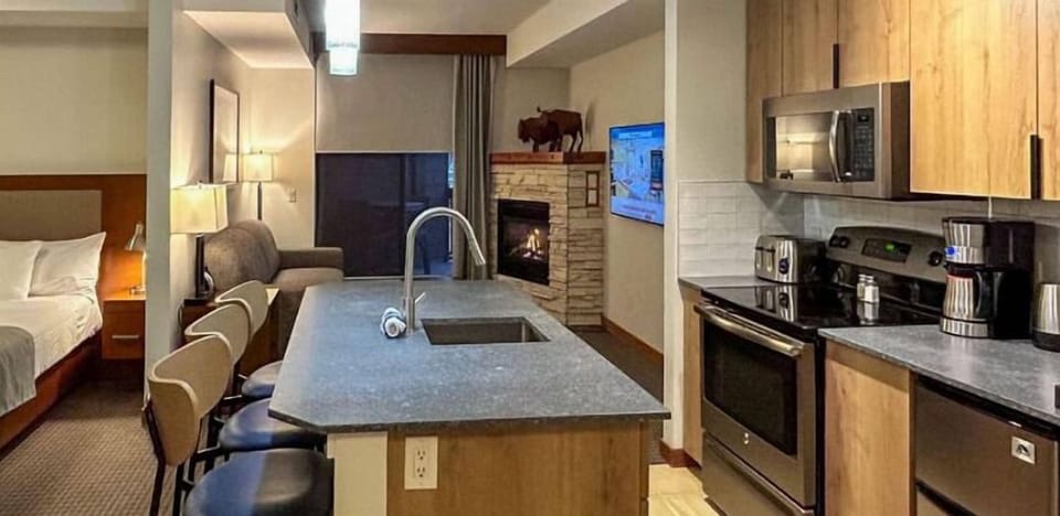 Stylish open-concept kitchen with modern appliances and a spacious island, seamlessly flowing into the cozy living and sleeping areas.