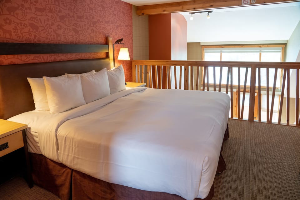Head upstairs to the cozy loft bedroom featuring a luxurious king-sized bed.