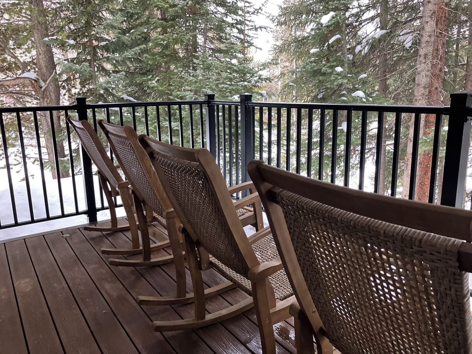 Cozy wooden rocking chairs await you on this peaceful deck, where you can sip your morning coffee surrounded by snow-dusted evergreens.