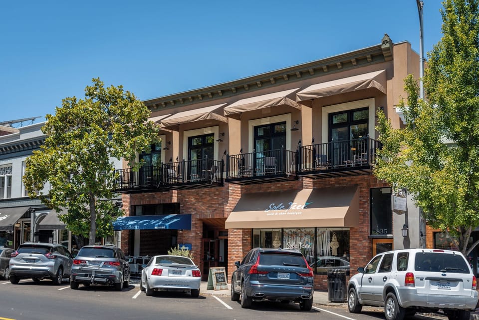 Brick storefronts and balcony seating create a lively downtown backdrop.