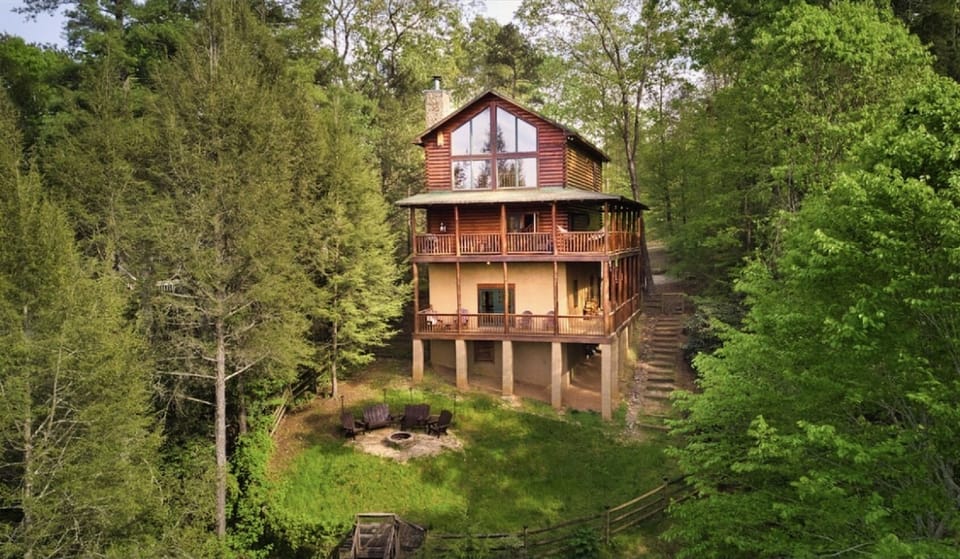 View of back showing 2 wraparound decks, firepit, fenced backyard