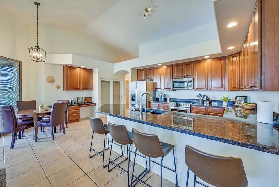 Enjoy cooking and dining in this open-concept kitchen featuring granite countertops, stainless steel appliances, and a large island. The adjacent dining area is perfect for family meals or entertaining guests, offering a warm and inviting atmosphere.