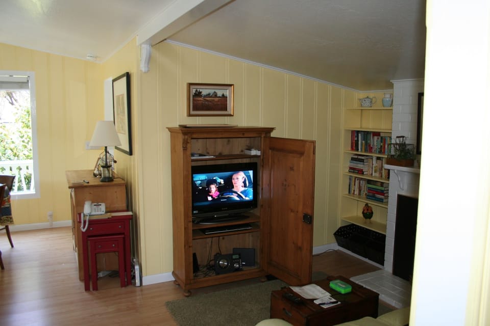 Vintage pine cabinet holds TV and media equipment.