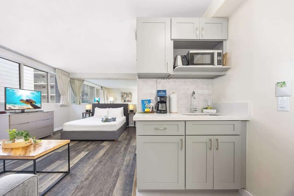 This charming studio offers a queen bed, a sleeper sofa, a kitchenette, and a full bathroom, combining relaxation and convenience in a modern layout.