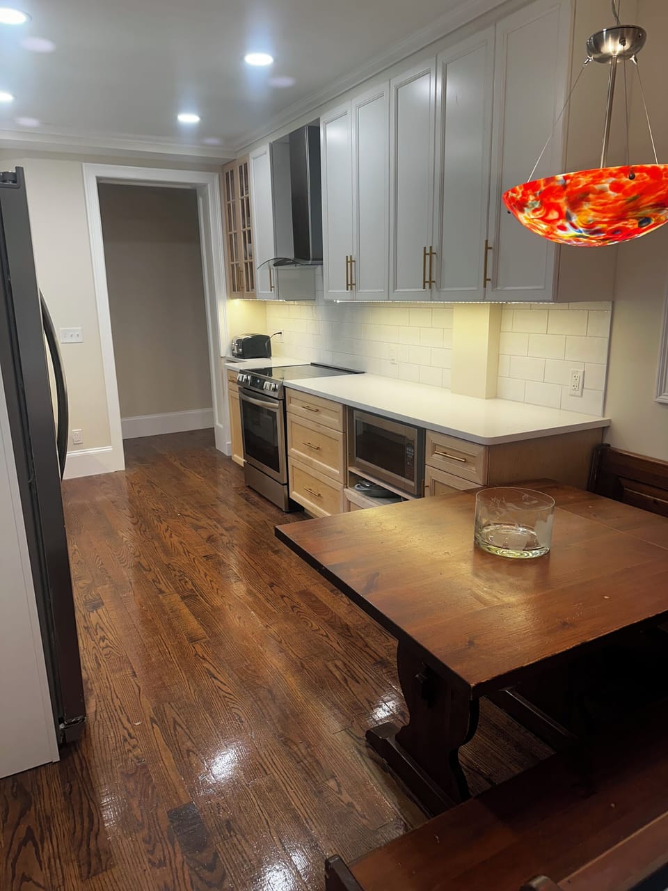 Modern fully equipped eat-in kitchen with new appliances and farmhouse sink.
