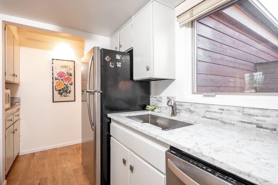 2nd photo of very fully stocked galley kitchen with quartz counters