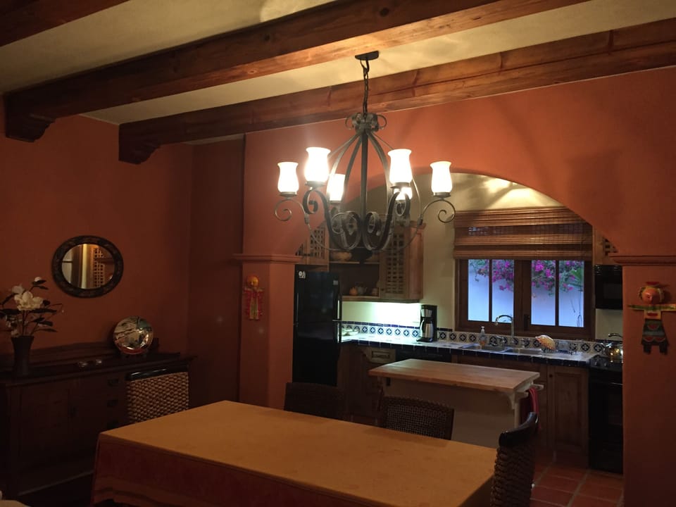 Dining room with wood-beam ceilings and kitchen.