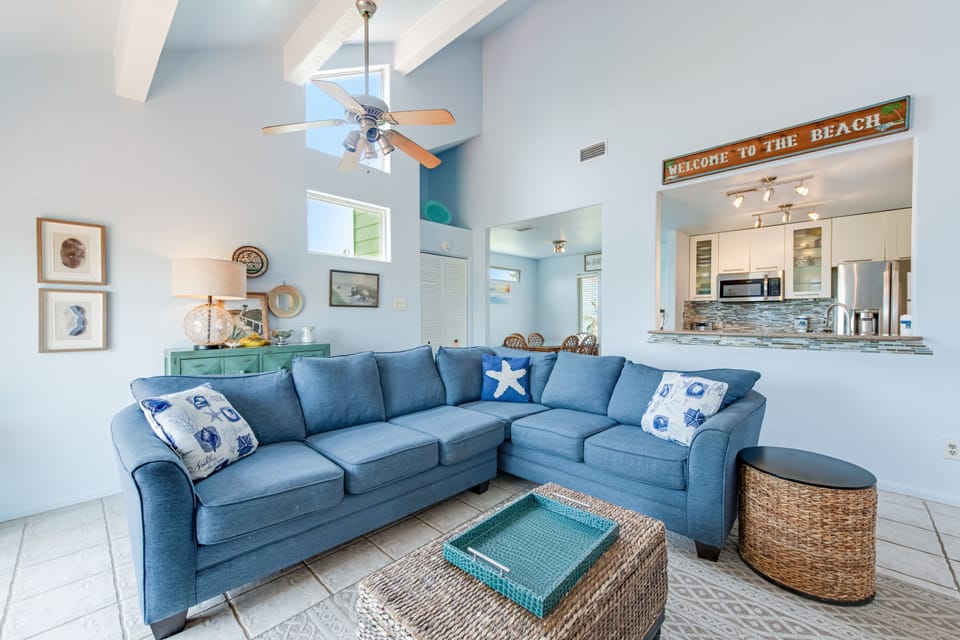 Sink into coastal comfort on your plush blue sectional, where beach vibes meet modern style in this airy, light-filled retreat.