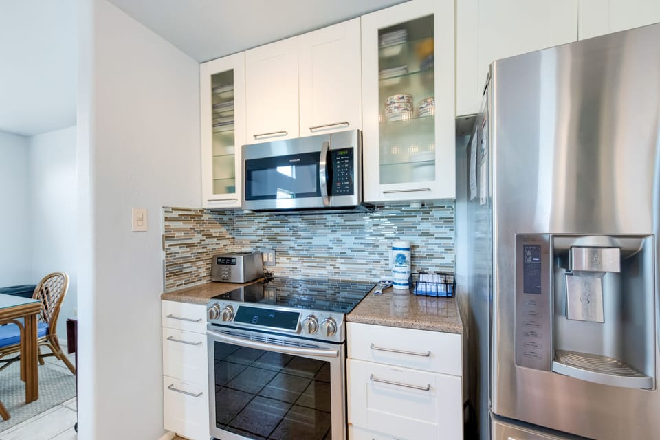 Your fully equipped kitchen features stainless steel appliances, granite countertops, and a stylish mosaic backsplash for memorable home-cooked meals.