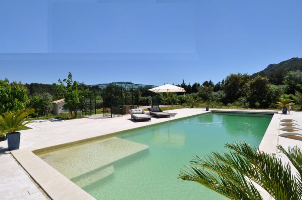 Heated pool together with sun beds and shaded seating area under the gazebo