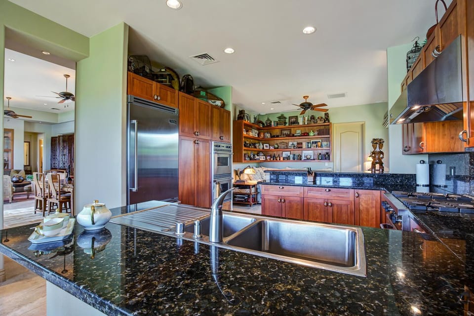 Open-concept kitchen features granite countertops; family room visible at back