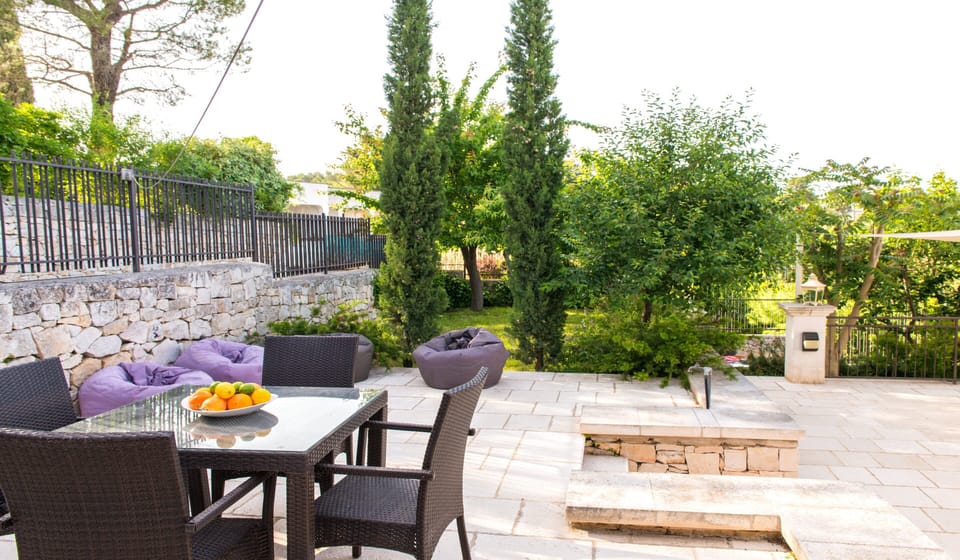 Barbecue area with dining table and garden area - adjacent to pool