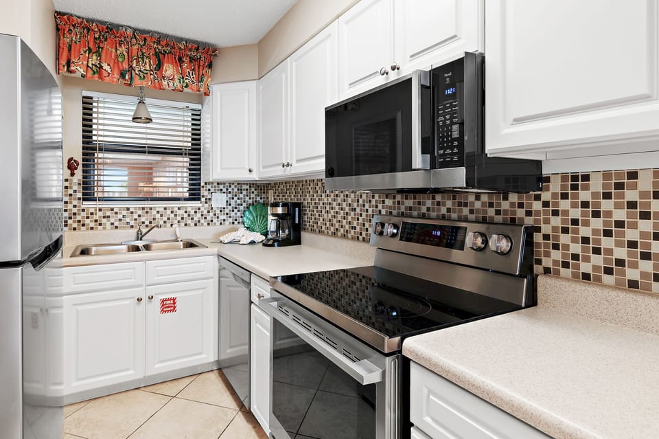 Your fully equipped kitchen awaits with modern appliances, stylish tile backsplash, and everything you need to prepare meals during your stay.