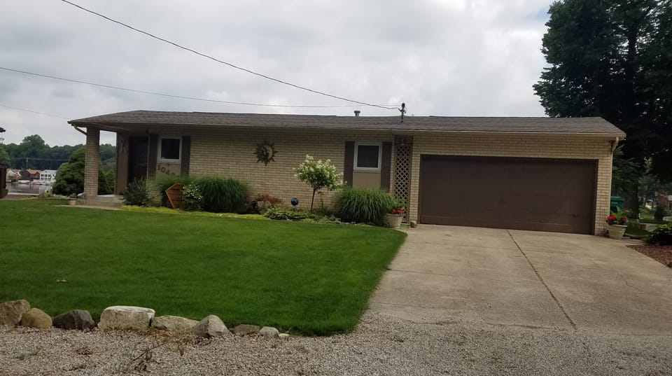 Street view of the house and driveway,  with extra parking in front