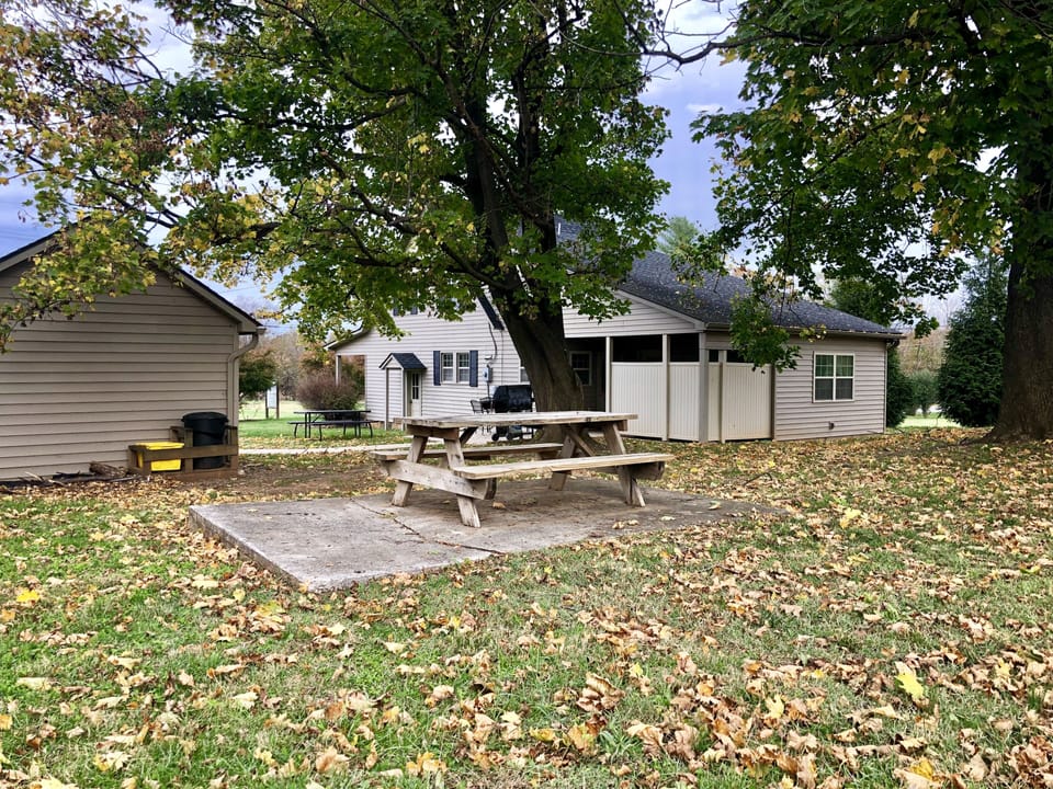 side porch and patio with picnic table, 4 top table, and grill