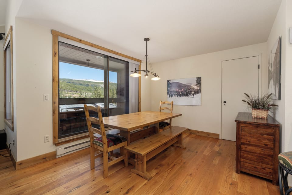 Gather around the rustic dining table where mountain views frame every meal through expansive windows.