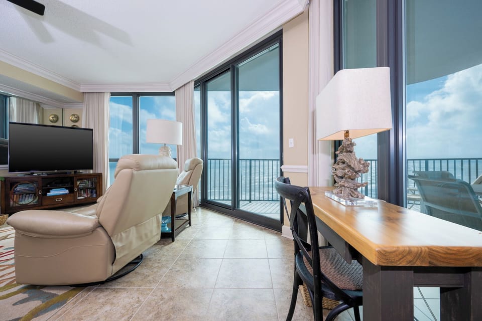 Unwind in the inviting living area with plush seating and a view of the balcony, perfect for relaxation
