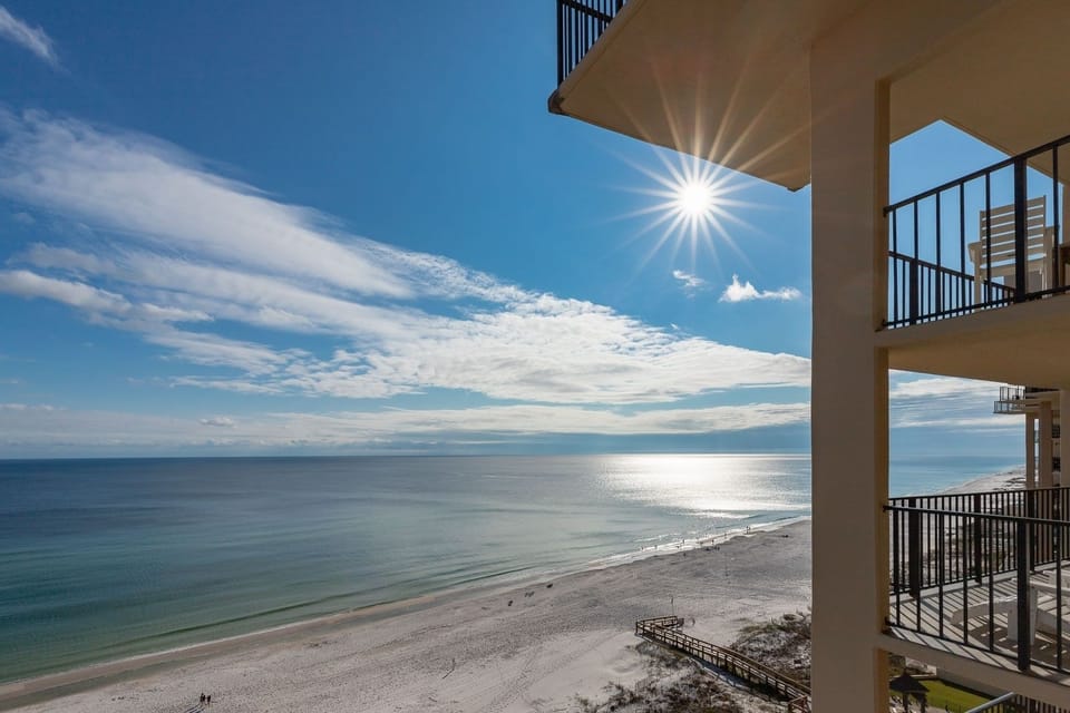 Experience the view of the serene shoreline under a bright sun, perfect for a relaxing beach getaway