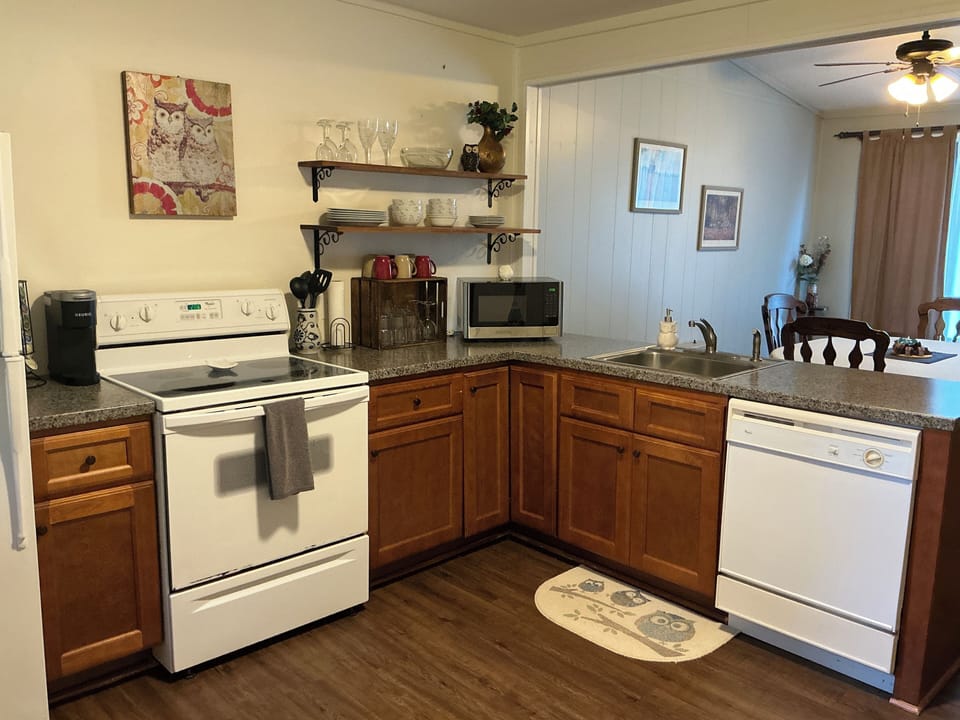 Kitchen with microwave, dishwasher, full fridge, oven, and Keurig coffee maker