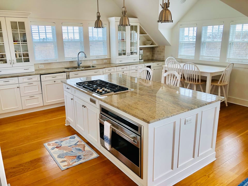Kitchen with oven, microwave, wine cooler, ice maker, coffee maker, and toaster.