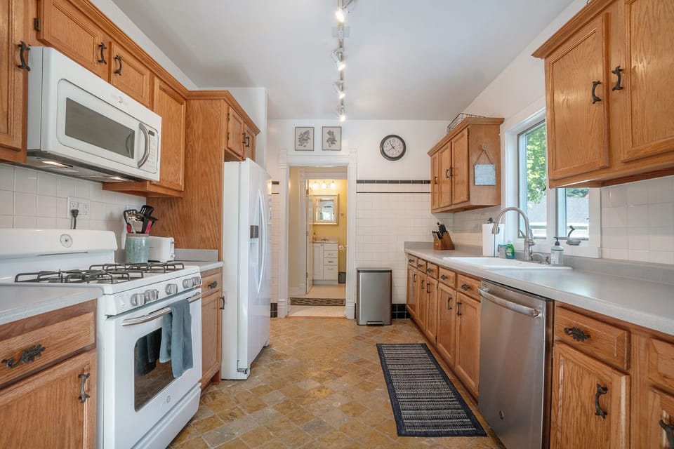 Kitchen with dishwasher, gas range, microwave, refrigerator with icemaker.