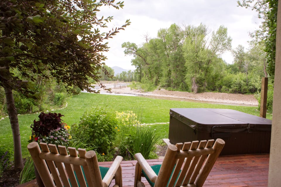 Large backyard patio with view of mountains and creek running in background