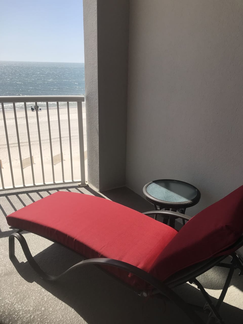 Cushioned Lounge Chair with Side Table on Balcony