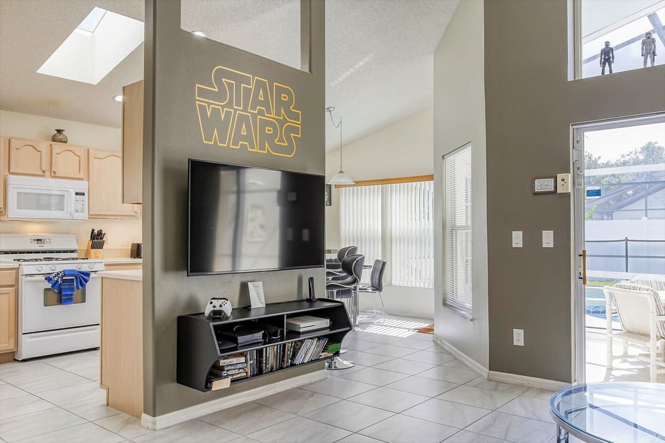 Wall-mounted, flat screen TV with Xbox One and video library.
