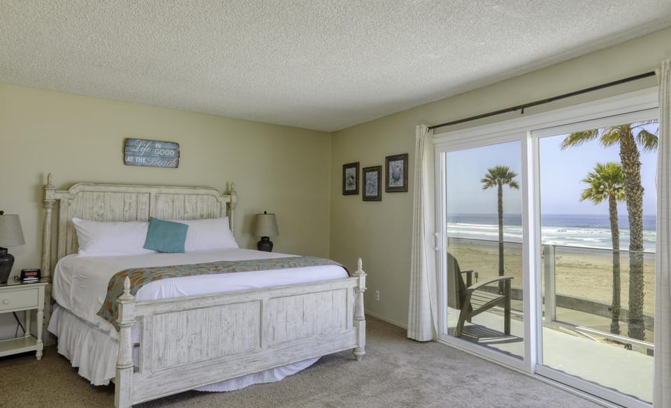 Master bedroom with California King and sliding glass door to private balcony