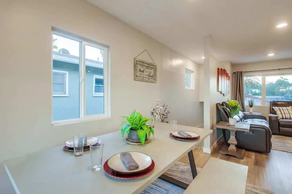 The indoor dining table is conveniently located next to both the kitchen and the outdoor deck, making it easy to enjoy meals and transition between spaces.