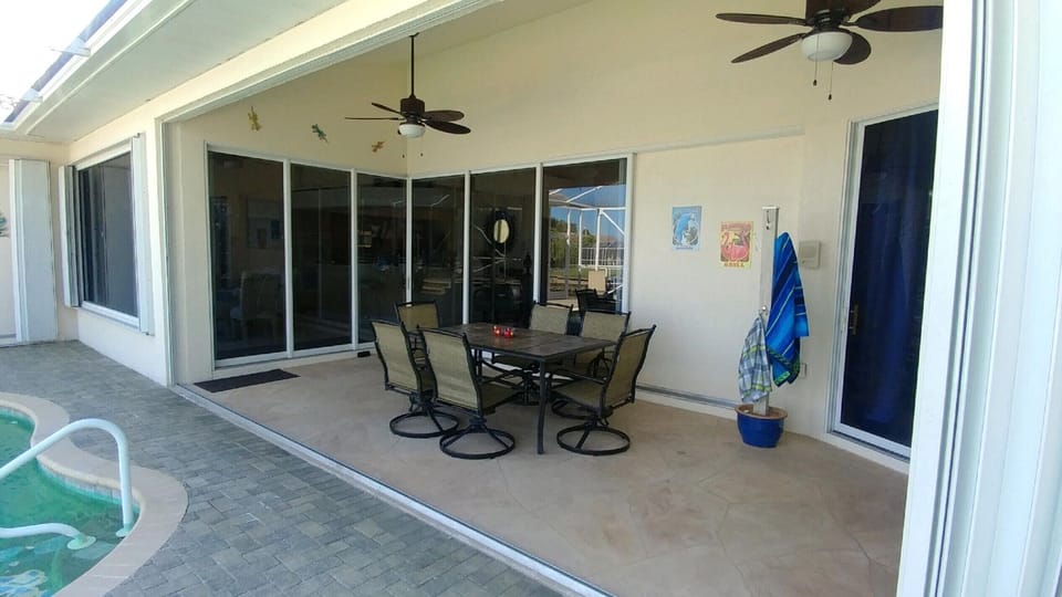 Outdoor ceiling fans over covered dining area in lanai