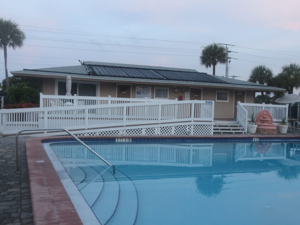 Condo clubhouse with bathrooms, plenty of chairs & tables for relaxing poolside!