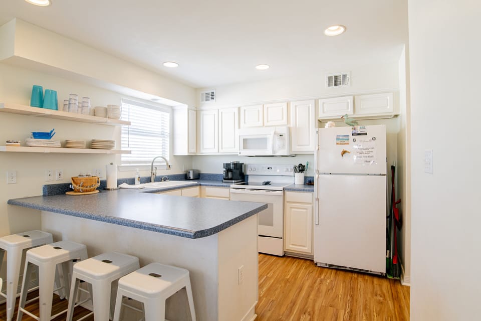 The stocked kitchen has fridge with icemaker, smoothtop stove/oven, microwave...