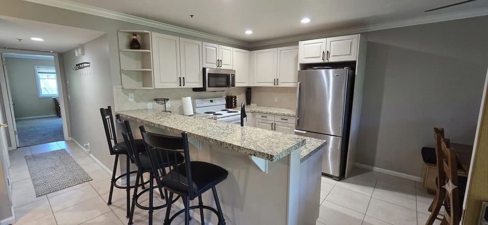 Fullystocked kitchen featuring modern appliances and ample granite counter space