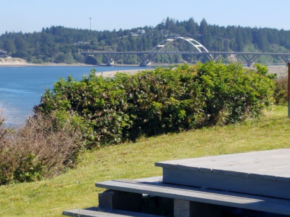 View over the deck, back yard, bay and bridge mid-afternoon. 
