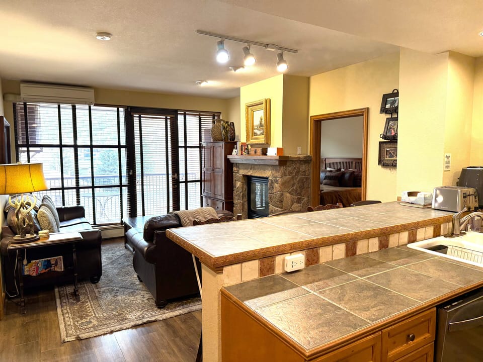 Open family/kitchen area with fireplace and access to deck with mountain view. 