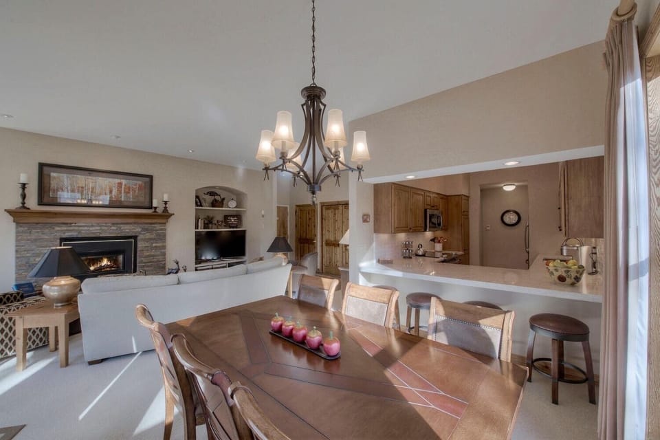 Dining room table with 6 chairs and 4 barstools at the counter.