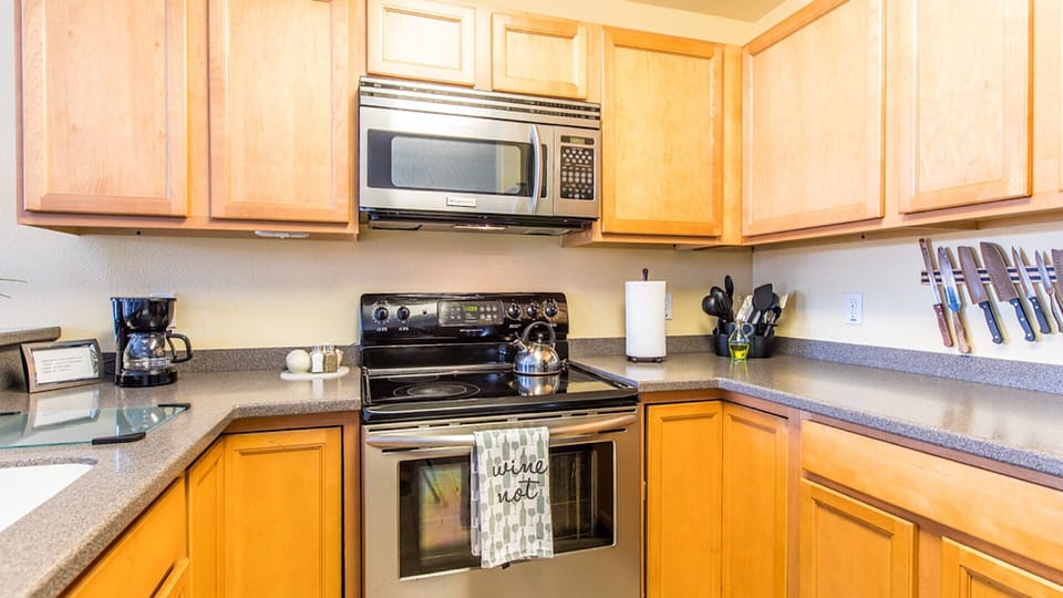 Full kitchen with pots and pans, plates, utensils. 