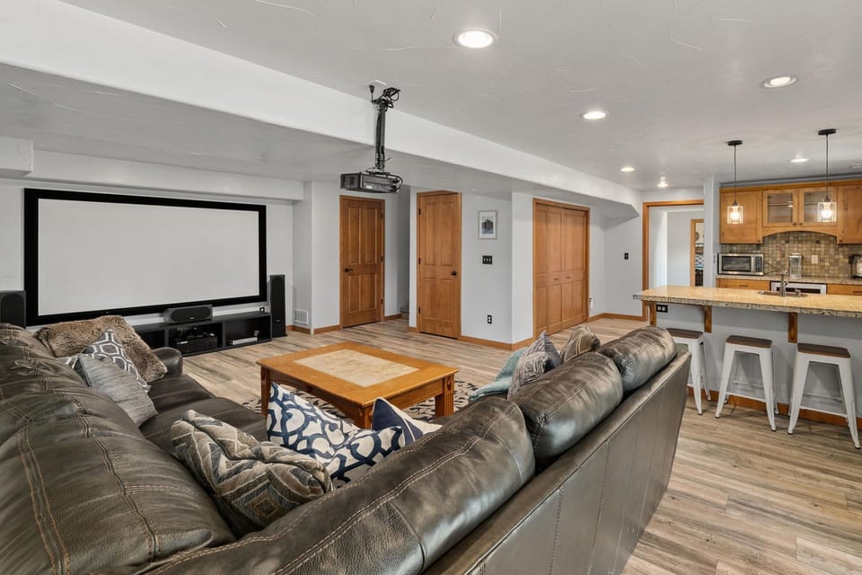 The den includes a kitchenette with a wine fridge, mini fridge and bar sink