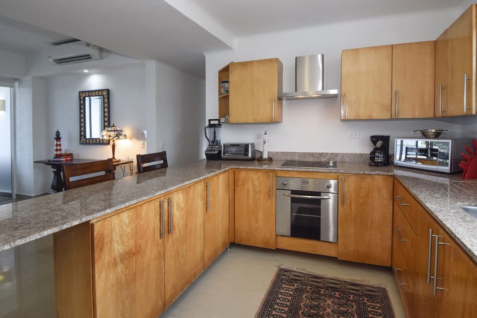 Kitchen with high end appliances, breakfast bar and dining room with Sea views