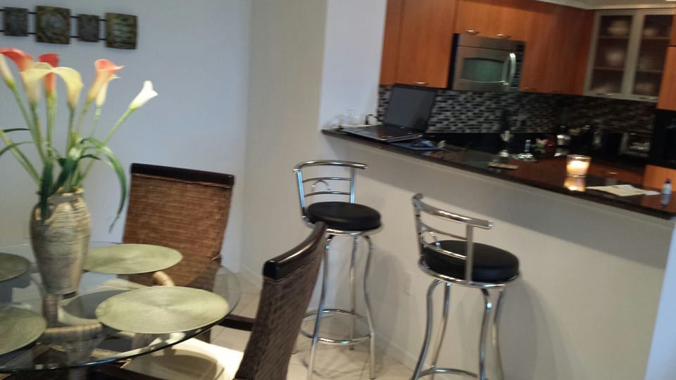 Kitchen with glass tile back splash and  stools