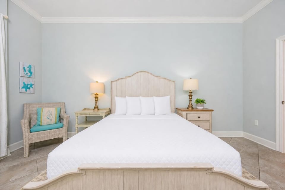 Relax in the queen guest bedroom, where soft bedding and light invite peaceful moments and serene beachside slumber