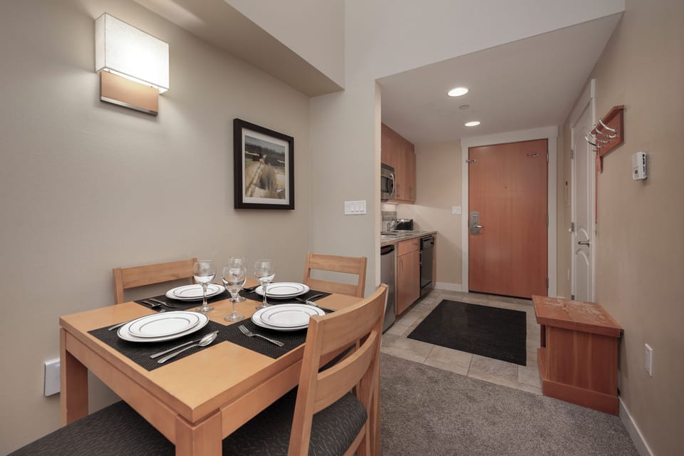 Gather around your dining table, perfectly set for four with elegant place settings and wine glasses ready for memorable meals together.