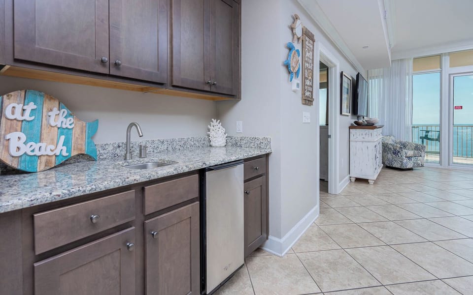 Grab a chilled drink from the fridge or create your favorite cocktail at the wet bar with coastal accents