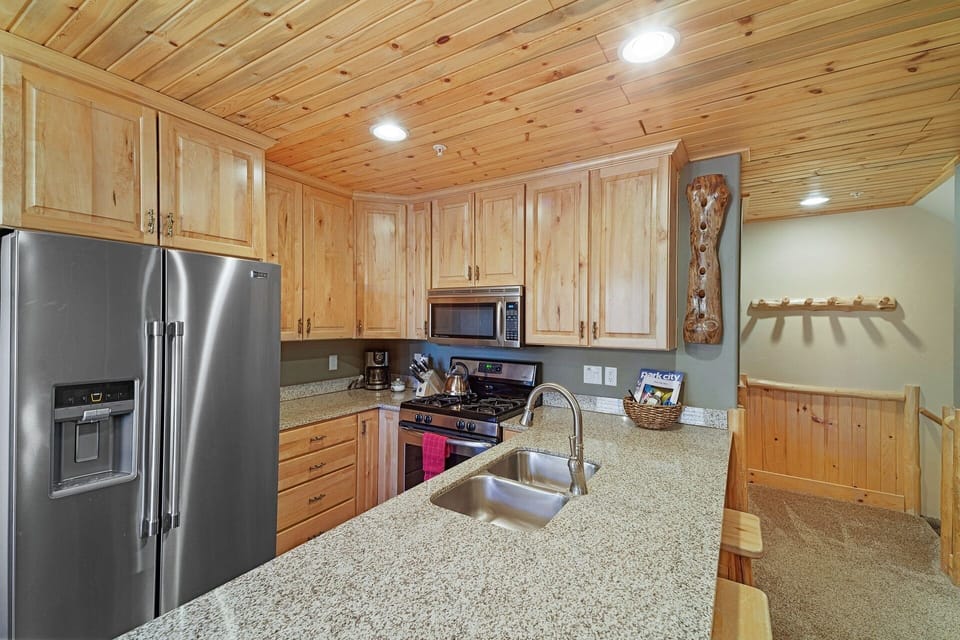 Efficient kitchen with gas range and breakfast bar. 