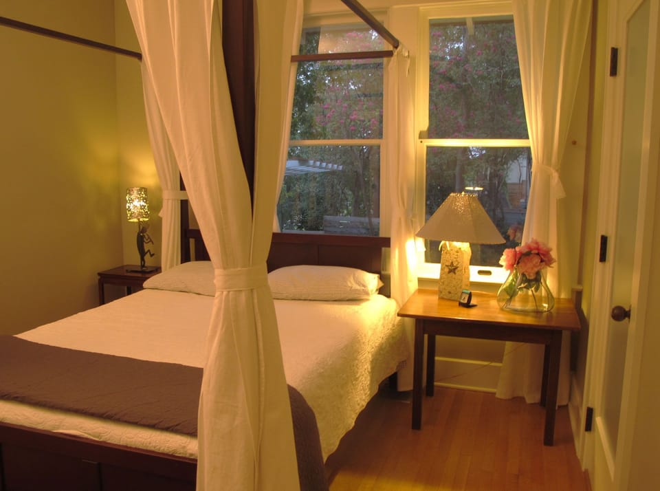Curtains provide privacy for the bed when sofa bed in living room is also in use