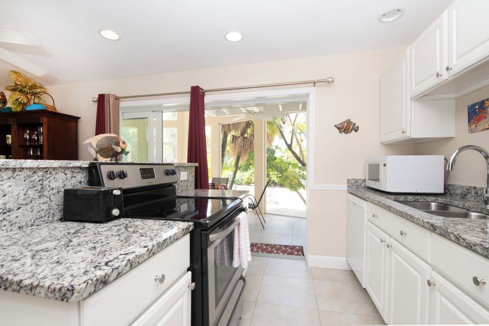 Kitchen area flowing into the home's two-story screened lanai porch.